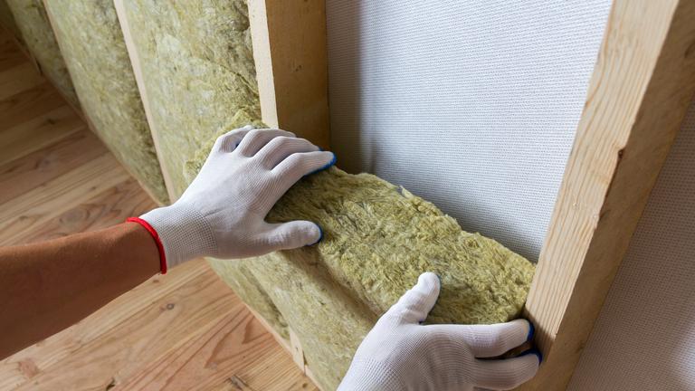 worker-hands-insulating-rock-wool-wooden-frame